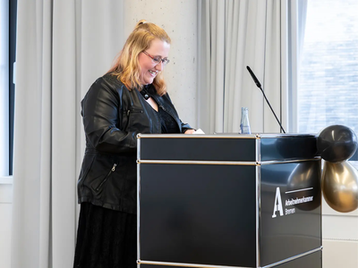 Eine junge Frau steht am Redepult | © Simone Hryzyk/AWO Bremerhaven